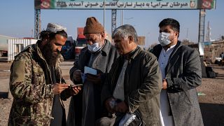 مقاتل من طالبان يفحص جوازات السفر عند معبر إسلام قلعة الحدودي بين أفغانستان وإيران. 2021/11/24
