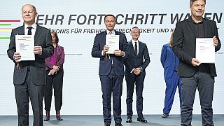 German leaders hold the coalition agreement signed between the SPD, the Greens and the FDP to form a federal government in Berlin, Tuesday, Dec 7, 2021