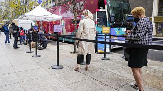 People wait in line for a COVID-19 vaccination at a NYC mobile vaccine clinic in Midtown Manhattan, Monday, Dec. 6, 2021.