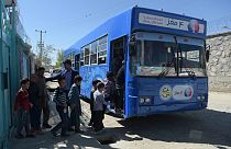 In this photograph taken on April 4, 2018, Afghan children board a mobile library bus in Kabul.
