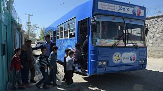 In this photograph taken on April 4, 2018, Afghan children board a mobile library bus in Kabul. 