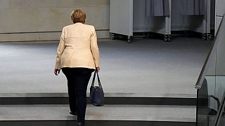 FILE - German Chancellor Angela Merkel leaves the plenary hall after a debate about the situation in Germany ahead of national elections in Berlin, Sept. 7, 2021.