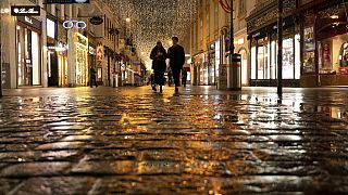 22 novembre 2021: nel primo giorno di lockdown, una coppia cammina davanti a negozi chiusi sul Graben, una strada nel centro di Vienna che è normalmente affollata 