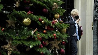 British PM Boris Johnson walks past a Christmas tree as he leaves 10 Downing Street to attend the weekly PMQ at the Houses of Parliament, in London, Dec. 1, 2021.