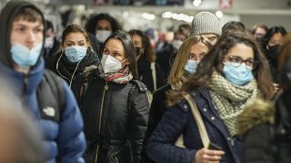 Commuters wearing face masks to protect against COVID-19 while walking through the La Defense business district transportation hub in Paris, Wednesday, Dec. 8, 2021
