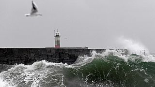 Waves crash over the breakwater by Newhaven Lighthouse as Storm Barra passes through Newhaven, southern England on December 7, 2021.