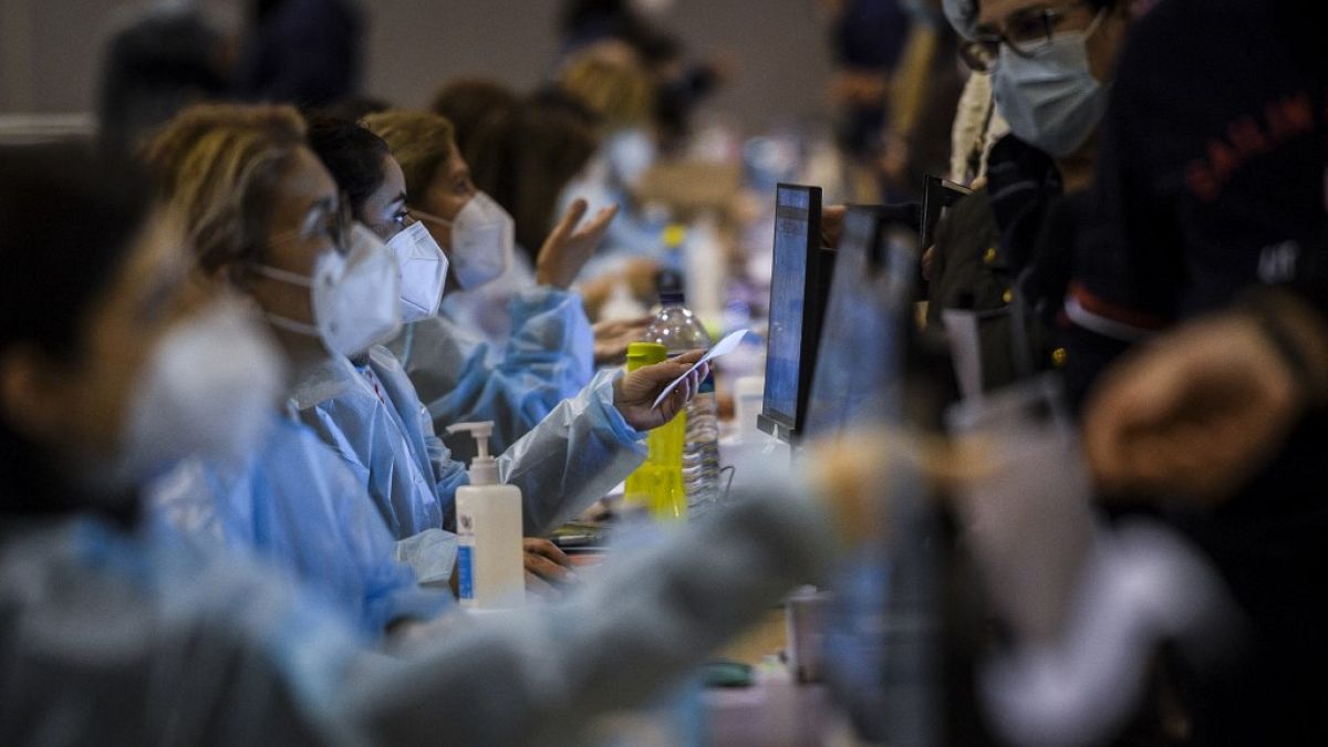Healthcare workers register people who will receive a dose of Covid-19 vaccine, at the vaccination centre of Parque das Nacoes in Lisbon on December 1, 2021.