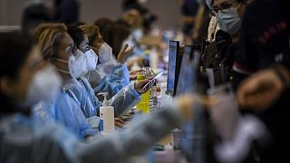 Healthcare workers register people who will receive a dose of Covid-19 vaccine, at the vaccination centre of Parque das Nacoes in Lisbon on December 1, 2021.