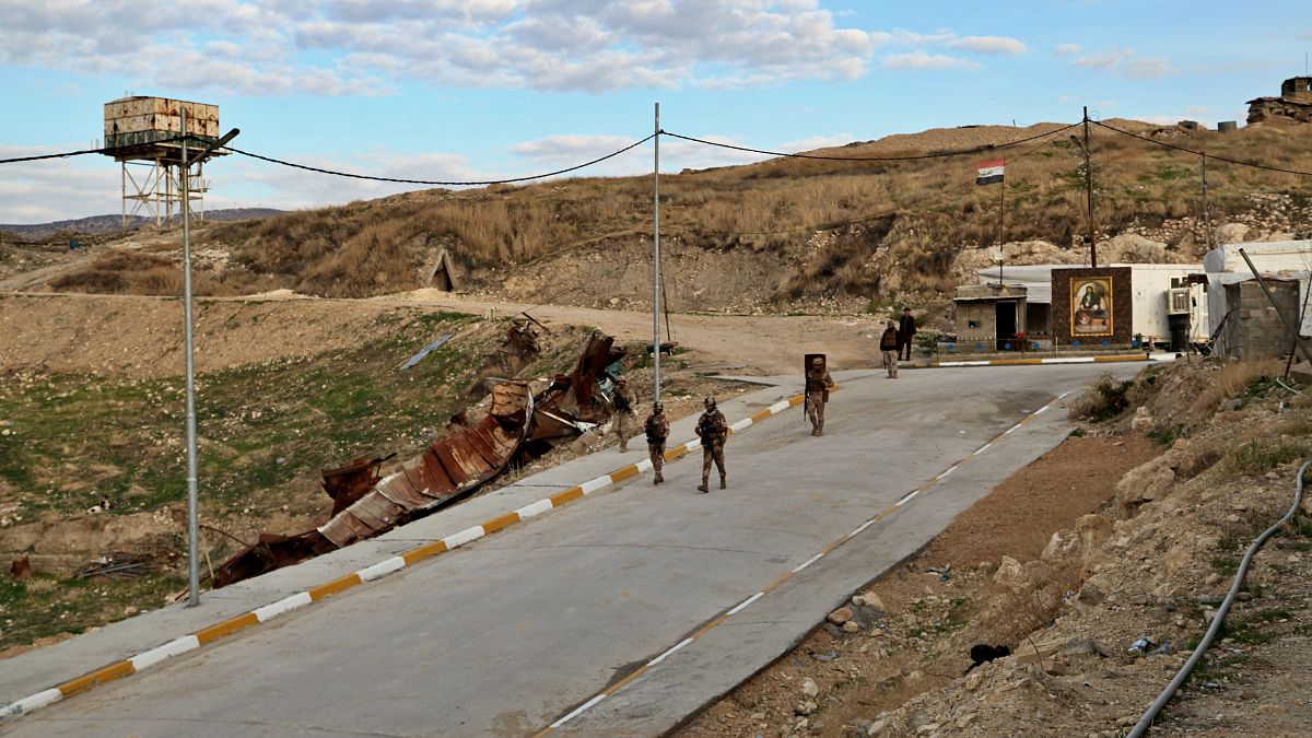 عناصر من الجيش العراقي يسيرون على الطريق المؤدي إلى مرقد السيدة زينب في سنجار، العراق.