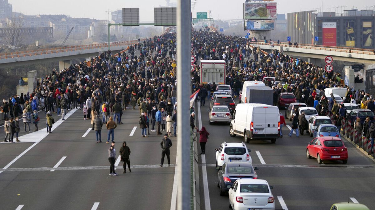 Protesters stand on the highway during a protest in Belgrade, Serbia, Saturday, Dec. 4, 2021.