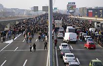 Protesters stand on the highway during a protest in Belgrade, Serbia, Saturday, Dec. 4, 2021.