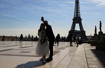 Tourists take a selfie on Trocadero with the Eiffel Tower in background on a sunny day in Paris