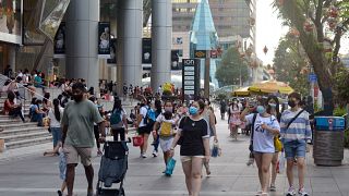 أناس برتدون الكمامات في أحد شوارع سنغافورة. 2021/11/28