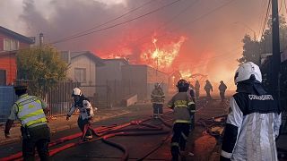 Bomberos trabajan en un incendio forestal que afectó a decenas de casas en la comuna, 9/12/2021. Castro, Chile