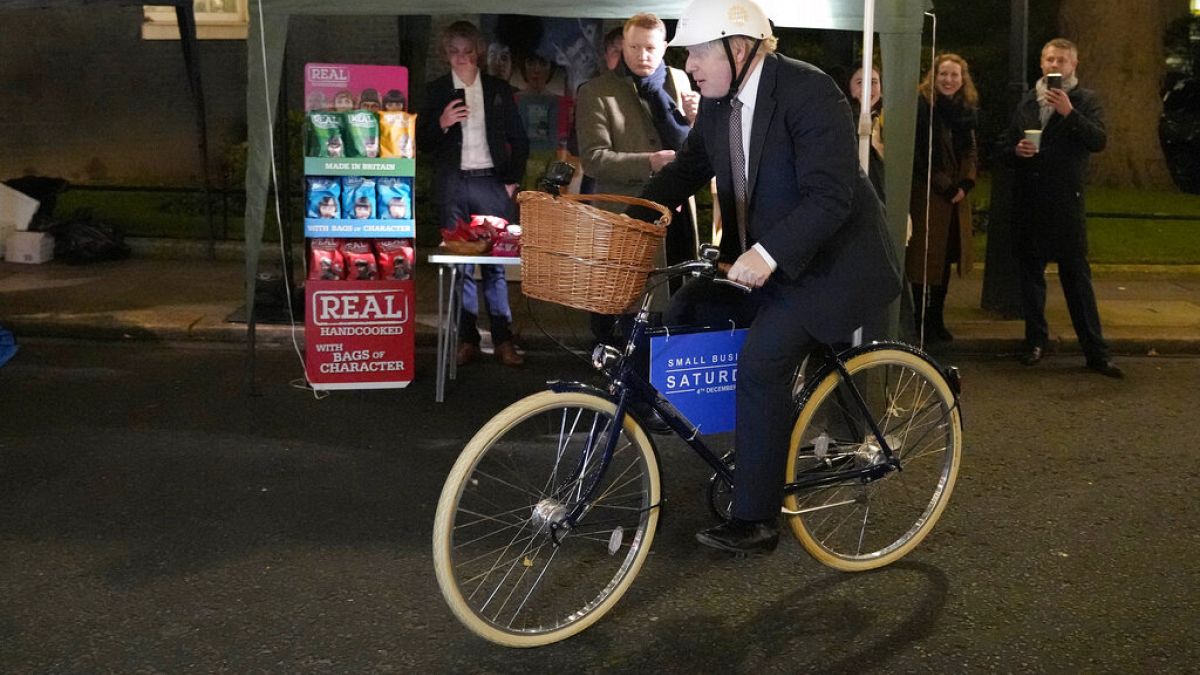 El primer ministro británico, Boris Johnson, monta en bicicleta mientras asiste a un mercado de alimentos y bebidas del Reino Unido instalado en Downing Street, en Londres