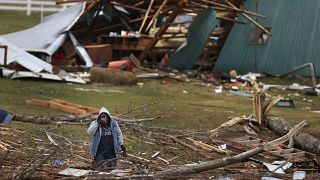 A woman searches for valuables amidst the remnants of a home on Saturday, Dec.11, 2021, on Highway F in Defiance, Mo. 