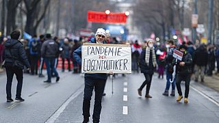 Un manifestant tenant une pancarte lors de la mobilisation contre les restrictions sanitaires, Vienne, Autriche, le 11 décembre 2021