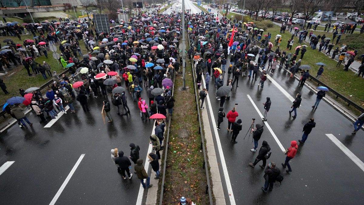 Protesters stand on the highway during a protest in Belgrade, Serbia, Saturday, Dec. 11, 2021.