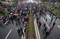Protesters stand on the highway during a protest in Belgrade, Serbia, Saturday, Dec. 11, 2021.