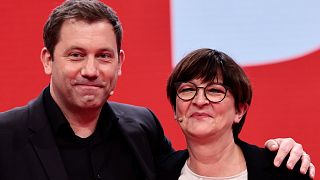 New-elected SPD co-leader Lars Klingbeil, left, poses with re-elected SPD co-leader Saskia Esken, right, at a party congress 11 Dec. 2021.