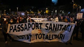 Demonstrators hold a banner reading "health passport, totalitarian state", during a demonstration against the Covid-19 health pass in Barcelona, 11 December 2021.