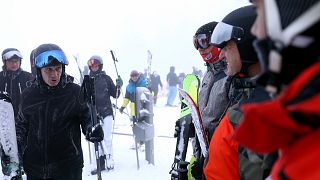 Skiers wait in a lift line on Mount Jahorina, 30 kilometers south of the Bosnian capital of Sarajevo, Saturday, Dec. 11, 2021.