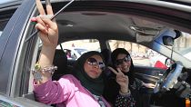 Libya'da 2012'de gerçekleştirilen parlamento seçimlerinde oy kullandıktan sonra araçlarında basına poz veren iki kadın/ Trablus (arşiv)