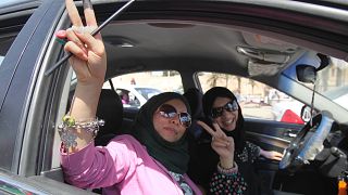 Libya'da 2012'de gerçekleştirilen parlamento seçimlerinde oy kullandıktan sonra araçlarında basına poz veren iki kadın/ Trablus (arşiv)