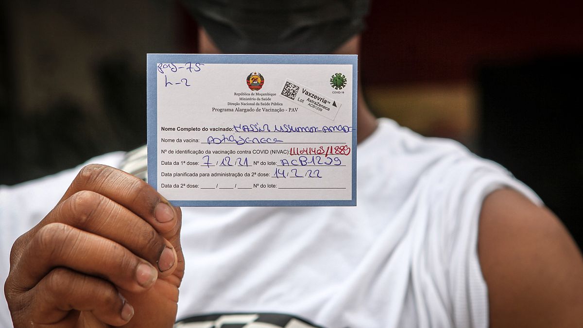 Jovem exibe cartão de vacinação pouco depois de tomar a primeira dose da vacina Vaxzevria, Maputo, Moçambique