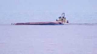 A rescue boat navigates by the capsized Danish cargo ship Karin Hoej after it collided with British cargo vessel Scot Carrier in the Baltic Sea, Dec. 13, 2021.