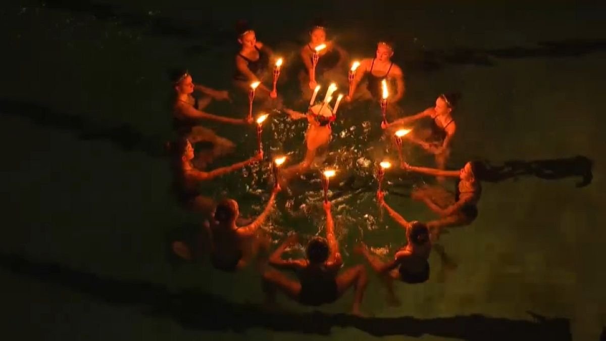 سباحات نادي السباحة المتزامنة نيبتون يؤدون عرضًا لمهرجان سانتا لوسيا للضوء في مسبح في ستوكهولم.