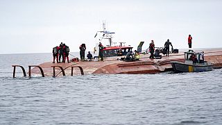 Des plongeurs se préparent à chercher les deux personnes disparues, sur le cargo danois retourné après la collision, au large de la Suède