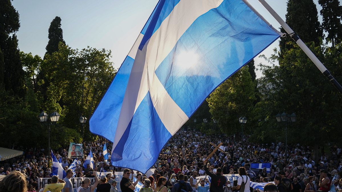 Anti-vaccine protester hold Greek flags during demonstration at Syntagma square, central Athens in July.