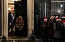 il premier britannico Boris Johnson esce dal 10 di Downing Street mentre un coro di bambini canta durante la cerimonia dell'albero di Natale, Londra, 1 dicembre 2021