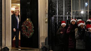 il premier britannico Boris Johnson esce dal 10 di Downing Street mentre un coro di bambini canta durante la cerimonia dell'albero di Natale, Londra, 1 dicembre 2021