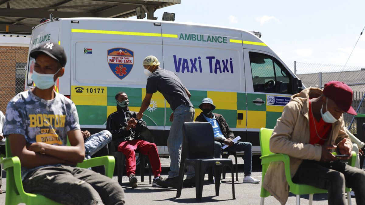 Menschen warten darauf, bei einem mobilen "Vaxi Taxi" geimpft zu werden. Kapstadt, Südafrika, Dienstag, 14. Dezember 2021. 