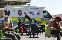 Menschen warten darauf, bei einem mobilen "Vaxi Taxi" geimpft zu werden. Kapstadt, Südafrika, Dienstag, 14. Dezember 2021.