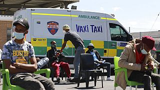 Menschen warten darauf, bei einem mobilen "Vaxi Taxi" geimpft zu werden. Kapstadt, Südafrika, Dienstag, 14. Dezember 2021.