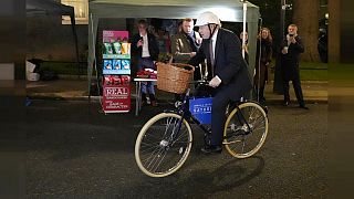 Premierminister Boris Johnson auf einem Fahrrad, während er einen Lebensmittel- und Getränkemarkt in der Downing Street in London besucht