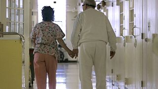 ممرضة تمسك بيد مسن مصاب بمرض الزهايمر، في منشأة كاليفورنيا الطبية في فاكافيل، كاليفورنيا، 9 أبريل / نيسان 2008