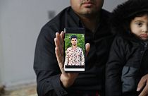 Zana Mamand, shows a photo of his missing brother, Twana Mamand, who was lost at sea in the English Channel trying to get to the UK, in Ranya, Iraq, Tuesday, Nov. 30, 2021.