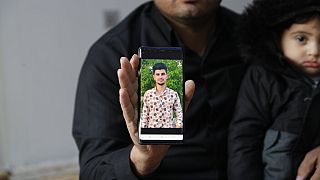 Zana Mamand, shows a photo of his missing brother, Twana Mamand, who was lost at sea in the English Channel trying to get to the UK, in Ranya, Iraq, Tuesday, Nov. 30, 2021.