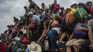 Migrantes tratan de subir a un trailer en Jesús Carranza, en el estado mexicano de Veracruz
