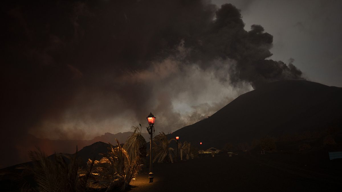 FILE - Ash covers the streets and houses in Las Manchas village as lava flows from the volcano, on the Canary island of La Palma, Spain, Dec. 6 2021.