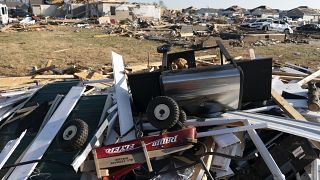 A Radio Flyer wagon lies among debris along Moss Creek Avenue Tuesday, Dec. 14, 2021, in Bowling Green, Ky.