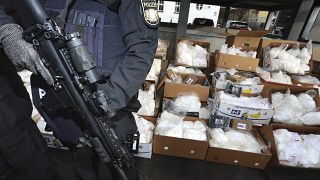 Police officers of the Bavarian riot police stand in front of about 1.5 tons of cocaine that are ready for transport in Bavaria, Germany, Dec.15, 2021.