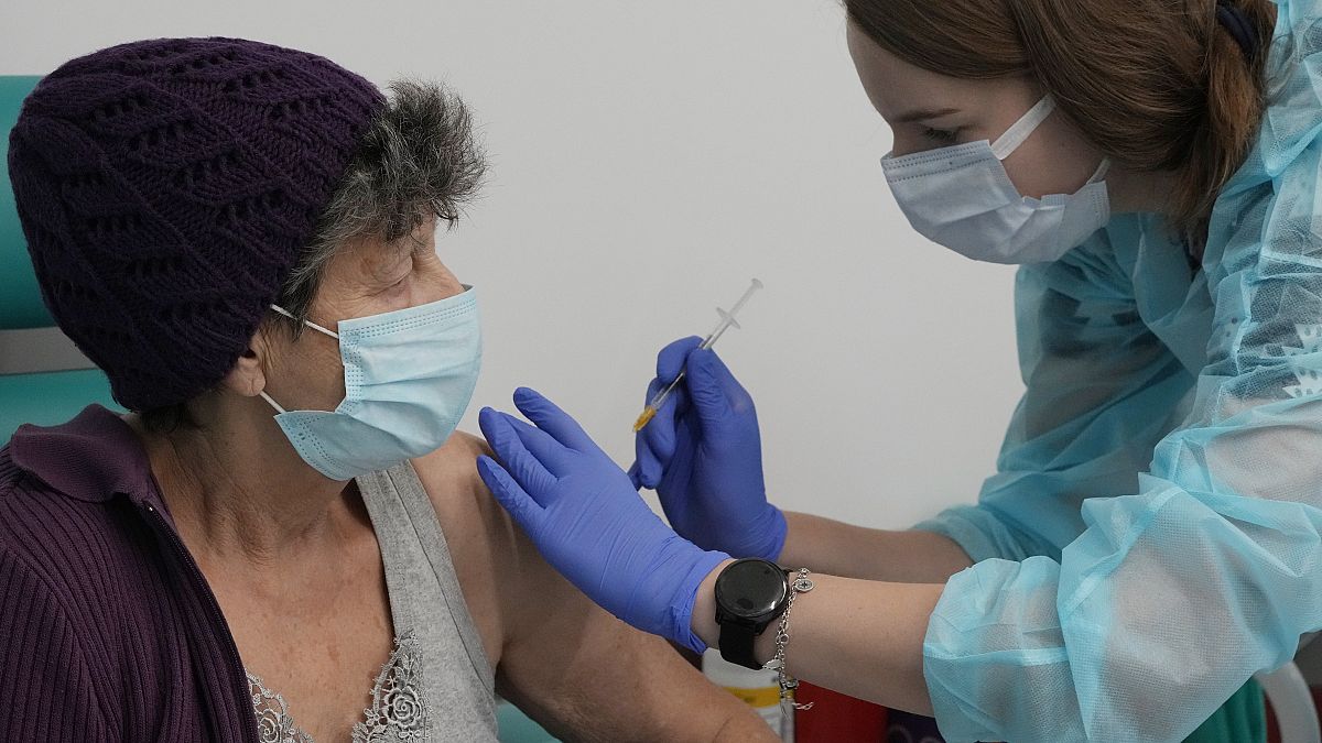 A resident of Warsaw receives a booster shot against COVID-19, in Warsaw, Poland, Tuesday Dec. 7, 2021.