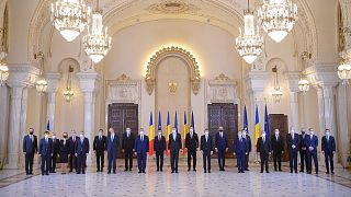 Romanian President Klaus Iohannis, center, poses with the newly sworn in government of Prime Minister Nicolae Ciuca at the Cotroceni Presidential Palace in Bucharest, Romania.
