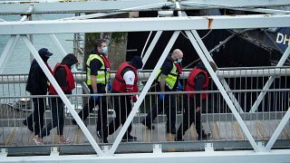 شرطة الحدود البريطانية يرافقون المهاجرين عند وصولهم إلى ميناء دوفر في جنوب شرق إنجلترا.