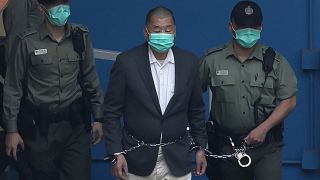 Jimmy Lai who founded the Apple Daily, is escorted by Correctional Services officers to get on a prison van before appearing in a court in Hong Kong. 